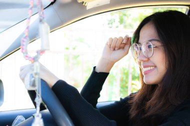 Siyahlar içinde Asyalı bir kadın gülümseme ve güvenle gideceği yere gitmeye hazırlanıyor..