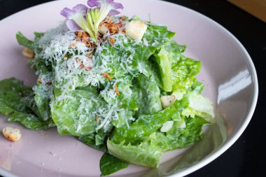 Siyah arkaplanlı bir tabakta çeşitli sebze salatası çeşitleri