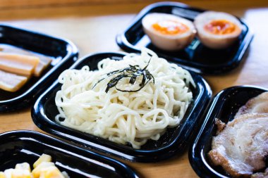 Siyah tepsiye konmuş taze ramen eriştesi.