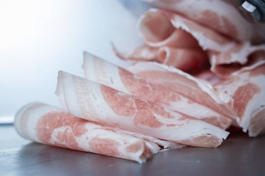 Top olana kadar sarılmış domuz eti. Eti otomatik olarak yuvarlak disklere kaydır Sukiyaki ya da shabu ile servis etmeye hazır ol.