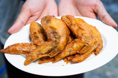 Tayland usulü kızarmış tavuk. Beyaz tabakta balık sosuyla marine edilmiş..