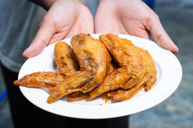 Tayland usulü kızarmış tavuk. Beyaz tabakta balık sosuyla marine edilmiş..