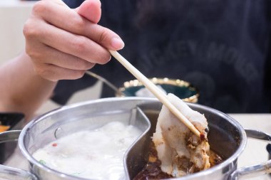 Shabu Shabu ve Sukiyaki. Yemek çubukları dilimlenmiş et çubukları, yemek çubukları ve sıcak tencere arkası..