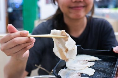 Shabu Shabu ve Sukiyaki. Yemek çubukları dilimlenmiş et çubukları, yemek çubukları ve sıcak tencere arkası..
