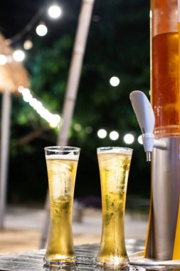 Bir bardak bira kulesi ve bulanık altın sarısı bir bokeh. Restoranda dinlenme zamanı..