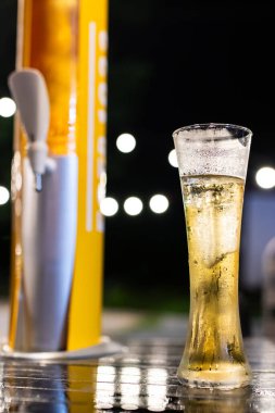 Bir bardak bira kulesi ve bulanık altın sarısı bir bokeh. Restoranda dinlenme zamanı..