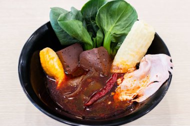 İçinde domuz kanı küpleri, yapraklı yeşiller, acı biber, dilimlenmiş domuz pastası, balık keki ve kızarmış tofu derisi olan canlı bir Asya çorbası. Acı biber yağıyla bezenmiş zengin kırmızı et suyu taze sebzelerle ve çeşitli sebzelerle çok güzel tezat oluşturuyor.