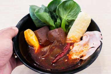 İçinde domuz kanı küpleri, yapraklı yeşiller, acı biber, dilimlenmiş domuz pastası, balık keki ve kızarmış tofu derisi olan canlı bir Asya çorbası. Acı biber yağıyla bezenmiş zengin kırmızı et suyu taze sebzelerle ve çeşitli sebzelerle çok güzel tezat oluşturuyor.