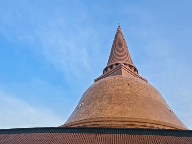 Phra Pathommachedi 'nin düşük açılı görüntüsü, Nakhon Pathom, Tayland' da büyük bir stupa. Yükselen altın-kahverengi kulesi açık mavi gökyüzüne yükseliyor, Budist mirasını ve ruhani görkemi simgeliyor..