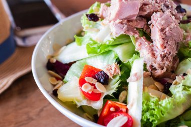 Marul, vişneli domates, dolmalık biber, ananas, badem ve soslu taze ton balığı salatası. Diyet, beslenme ve gıda reklamları için mükemmel renkli ve sağlıklı bir yemek..