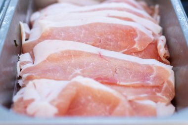 Lokantada veya büfede sıcak tencere, barbekü ya da shabu-shabu pişirmeye hazır, paslanmaz çelik bir tepside dizilmiş ince domuz eti dilimleri..