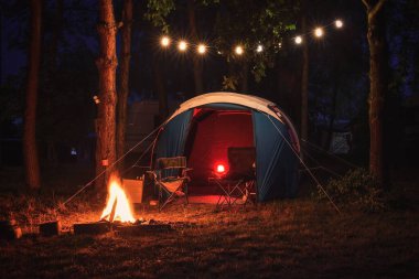Atmosferik gece macerası. Ormanda gece yarısı ateşi olan bir çadır..