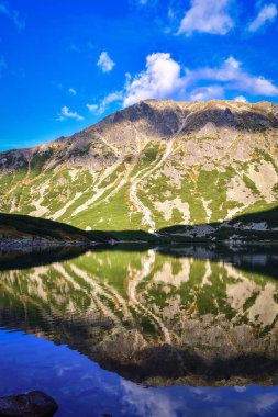 Muhteşem dağ yaz manzarası. Dağ zirveleri güzel bir göle yansıyor. Fotoğraf Polonya Tatra Dağları 'ndaki Gasienicowa Vadisi' nde çekildi..