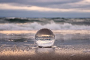 Soyut deniz kenarı fikri. Deniz manzarası cam bir küre içinde bulanık bir arka plan ile tutulur..