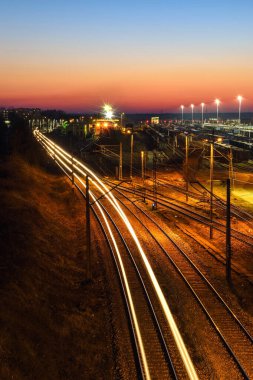 Akşam manzaralı bir tren istasyonunda. Polonya Kielce Herby İstasyonu 'ndaki tren rayları..