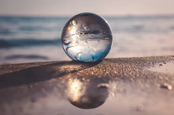 stock image Abstract idea with water with an interesting effect. Glass ball on a blurred background on a seaside beach in Gdynia, Poland. Photo with a shallow depth of field.