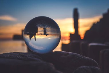 İlginç bir etkisi olan su ile soyut bir fikir. Polonya 'nın Gdynia sahilinde bulanık bir arka planda cam top. Sığ bir alan derinliği olan fotoğraf.