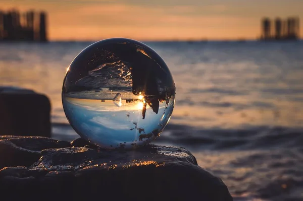 stock image Abstract idea with water with an interesting effect. Glass ball on a blurred background on a seaside beach in Gdynia, Poland. Photo with a shallow depth of field.