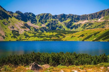 Dağlardaki güzel mavi göl. Beş Göl Vadisi 'ndeki göl ve Polonya' nın yüksek Tatra kentindeki dağ sırtı üzerinde resim gibi bir manzara uzanır..