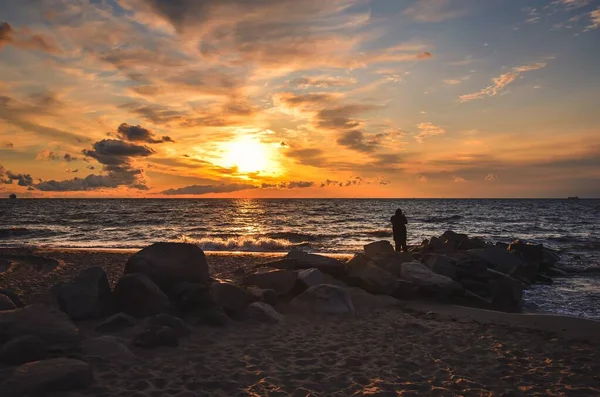폴란드 발트해의 아름다운 해변의 과떠오르는 태양을 배경으로 남자의 — 스톡 사진