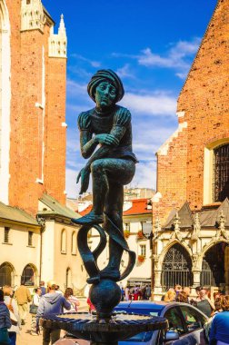 Krakow, Polonya - 16 Ağustos 2014: Krakov öğrencisinin heykeli. St. Mary Kilisesi 'ni ziyaret eden turistlerle dolu olan Krakow' daki St. Marys Meydanı 'nda anıt bulunuyor..