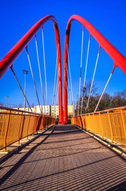 Şehir caddesinin üzerindeki metal köprü. Polonya 'nın Bydgoszcz kentindeki kırmızı modern köprü.