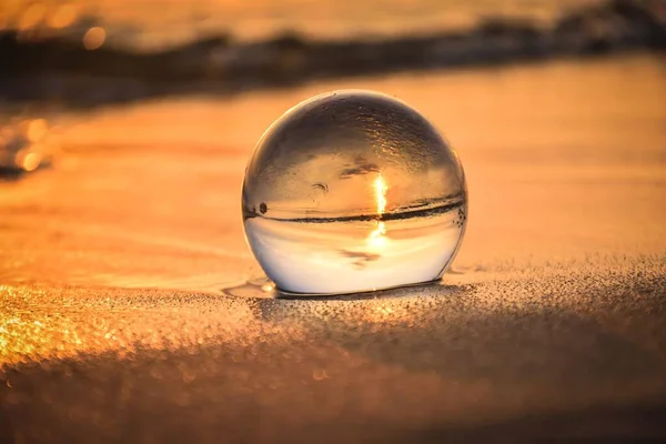 興味深い効果を持つ水と抽象的なアイデア ポーランドのジャスタルニアの海辺のビーチでぼやけた背景にガラスボール 被写界深度が浅い写真 — ストック写真
