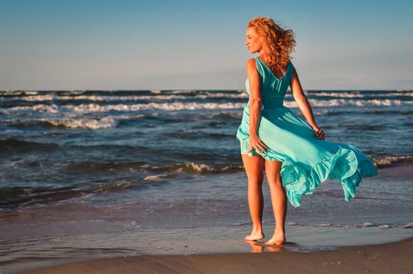 stock image Beautiful blonde woman on a sandy beach. Photo taken on the Baltic Sea in Leba, Poland. Photo with a shallow depth of field with blurred background. 