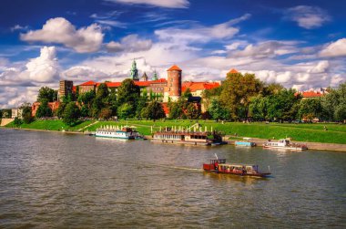 Krakow, Polonya - 16 Ağustos 2014: Wawel Kraliyet Kalesi, Krakow. Wawel Kraliyet Kalesi 'nin arka planında güneşli bir yaz günü Polonya' da, Vistula nehrinde turist tekneleri.