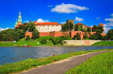 Krakow, Polonya - 16 Ağustos 2014: Wawel Kraliyet Kalesi, Krakow. Wawel Kraliyet Kalesi 'nin arka planında güneşli bir yaz günü Polonya' da, Vistula nehrinde turist tekneleri.