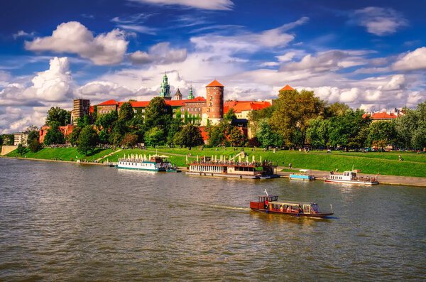 Krakow, Poland - August 16, 2014: Wawel Royal Castle in Krakow. Tourist boats on Vistula river with Wawel Royal Castle in the background on sunny summer day, Poland.