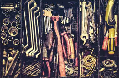 Kara metal bir kutuda atölye aletleri. Anahtarları, halka yayıcıları, çekiç, pense, tornavida, maymuncuk anahtarı, vida, cıvata, tel ve diğer (DIY) araçları tutmak için iç bölmeleri olan araç takımı.