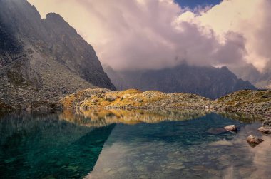 Slovak Tatra Dağları 'ndaki yaz manzarası. Güzel göl ve dağlık tepeler bulutlarda.