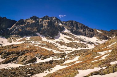 Erken bahar dağ manzarası. Slovakya 'nın Tatra dağlarındaki Beş Spis Göleti vadisindeki donmuş göller ve yüksek kayalık dağların üzerinde resim gibi bir manzara uzanır..