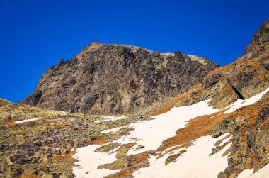 Erken bahar dağ manzarası. Slovakya 'nın Tatra dağlarındaki Beş Gölet Vadisi' ndeki yüksek kayalık zirvenin manzarası uzanıyor.
