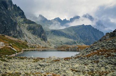 Slovak dağlarında dağ bulutlu manzara. Slovakya 'nın yüksek Tatra kentindeki bulutlarda güzel göl ve dağ zirveleri.