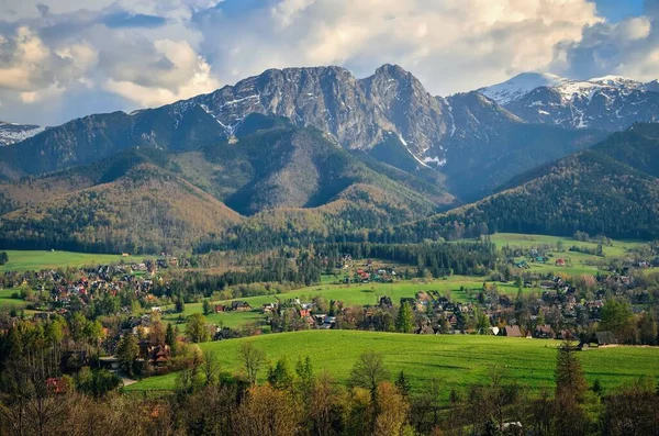 stock image Beautiful country view with mountains in the background. View of the Tatra Mountains and Koscielisko Village in Poland.