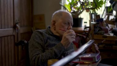 Elderly male master works in his workshop restoring japanese sword sheath