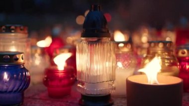 Azizler Günü bayramında gece mezarlıkta parlayan mumlar.