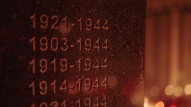 World war two monument tombstone lighted by the grave candles glowing on cemetery at night on All Saints Day
