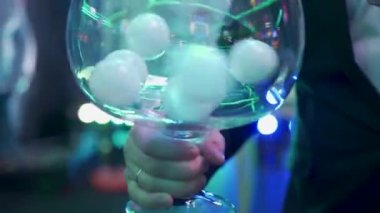 Lottery balls spinning in the glass by the host at the nightclub party