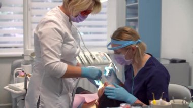 İşteki kadın dişçi asistanıyla hijyen prosedürü uyguluyor.