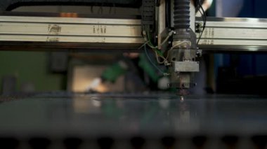 CNC lazer makinesinde çalışan teknisyen metal levha kesiyor