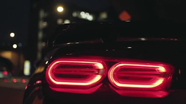 Czarne Sportowe Tylne Światło Samochodu Świecące Ciemności Nocnego Miasta Migające — Wideo stockowe