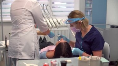 İşteki kadın dişçi asistanıyla hijyen prosedürü uyguluyor.