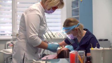 İşteki kadın dişçi asistanıyla hijyen prosedürü uyguluyor.