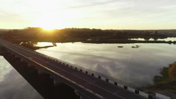 日没時に大規模な水によって農村ヨーロッパの田舎を通る道路の空中ビュー — ストック動画