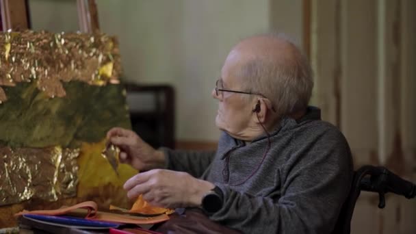 Starszy Artysta Wózku Inwalidzkim Stosuje Złoto Obrazu Olejnego Płótnie — Wideo stockowe