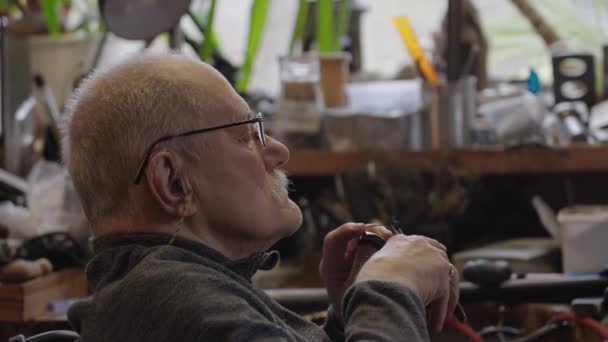 坐轮椅的年长的珠宝大师在一个车间工作 — 图库视频影像