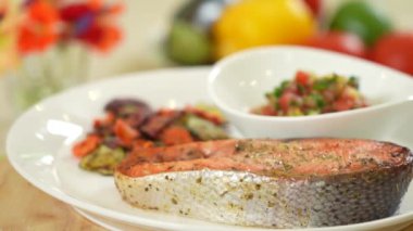 Fırında somon bifteği, ızgara sebze ve sebze salsa sosu.